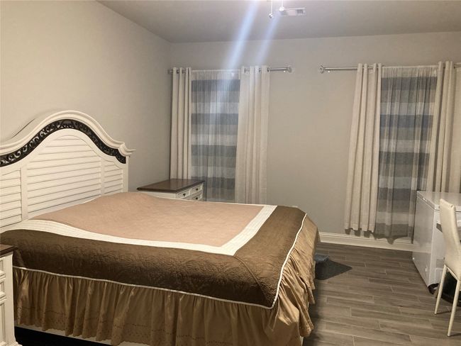 Bedroom with wood finished floors, visible vents, and baseboards | Image 18