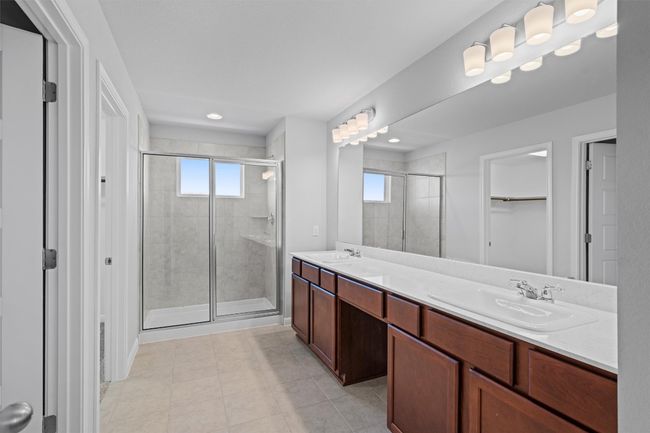 Full bathroom featuring a stall shower, double vanity, plenty of natural light, a spacious closet, and recessed lighting | Image 23