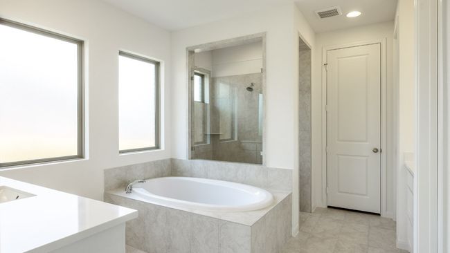 Bathroom featuring vanity, a bath, a shower, tile patterned floors, and recessed lighting | Image 9