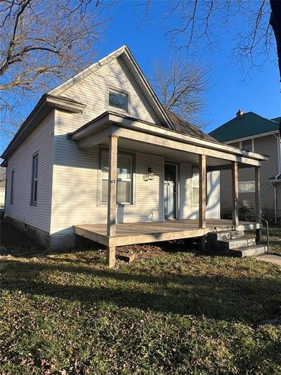 Rear view of house featuring covered porch and a lawn | Image 1