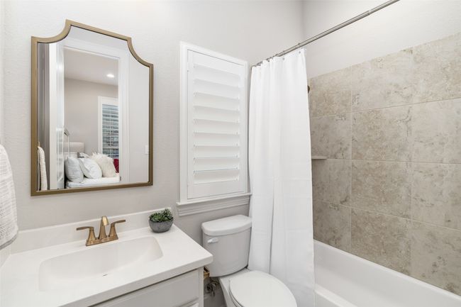 Secondary full bath features plantation shutters, shower and tub combination and upgraded finish outs like designer mirror and gold hardware. | Image 23