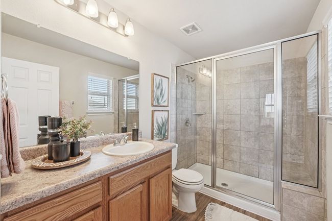 Bathroom with a shower stall, vanity, and wood finished floors | Image 15