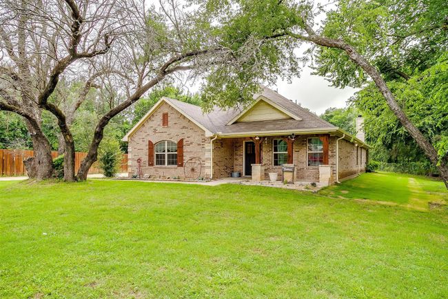 View of front of home with brick siding, a chimney, a shingled roof, and covered porch | Image 5