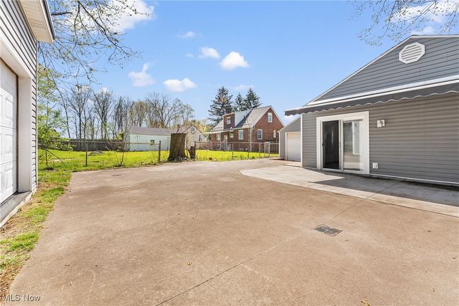 View of patio / terrace with a detached garage, fence, an outdoor structure, and a residential view | Image 9