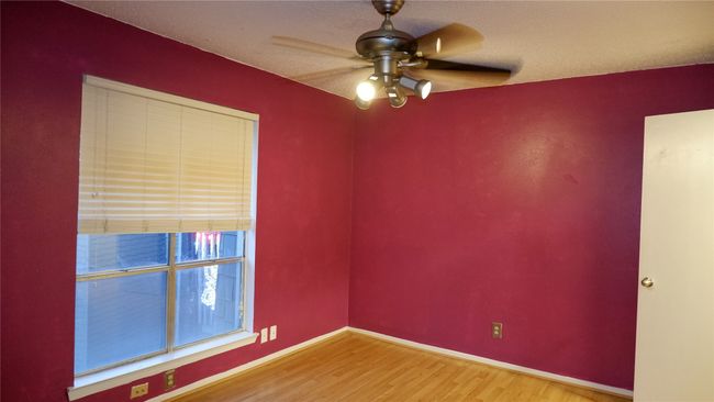 Empty room with ceiling fan, wood-type flooring, and a textured ceiling | Image 17