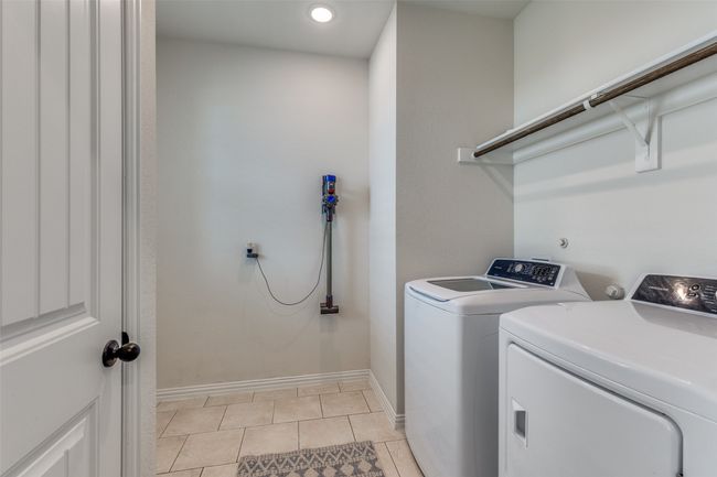 Laundry room featuring washer and dryer, light tile patterned floors, and recessed lighting | Image 19