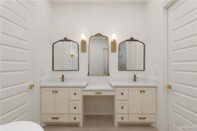 legant Primary Bath Vanity AreaLuxurious dual vanities with quartz countertops, gold hardware, and ornate framed mirrors—complete with a central makeup station and warm sconces for added sophistication. | Image 18