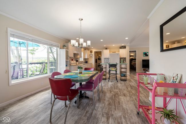 dining room featuring crown molding, a chandelier, wood finished floors, baseboards, and recessed lighting | Image 12