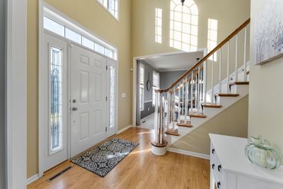 As you step through the front door, you are greeted with an inviting entryway and an open staircase soaring to an 18-foot ceiling. White enamel woodwork adds a touch of elegance throughout. | Image 2