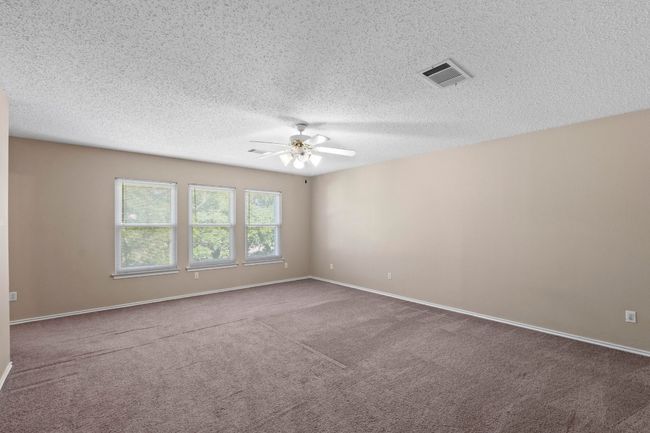 Unfurnished room featuring ceiling fan, carpet flooring, a textured ceiling, and baseboards | Image 19