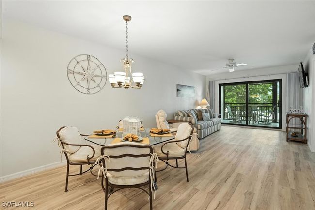 Dining space with light wood-style flooring, a chandelier, and a ceiling fan | Image 11
