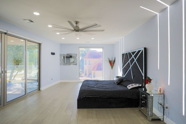 Bedroom with ceiling fan, access to exterior, hardwood / wood-style floors, and multiple windows | Image 13