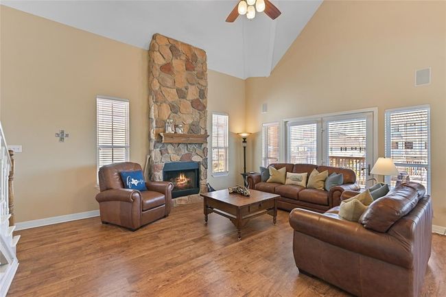 Spacious living room featuring a warm stone fireplace and expansive canal views. | Image 4