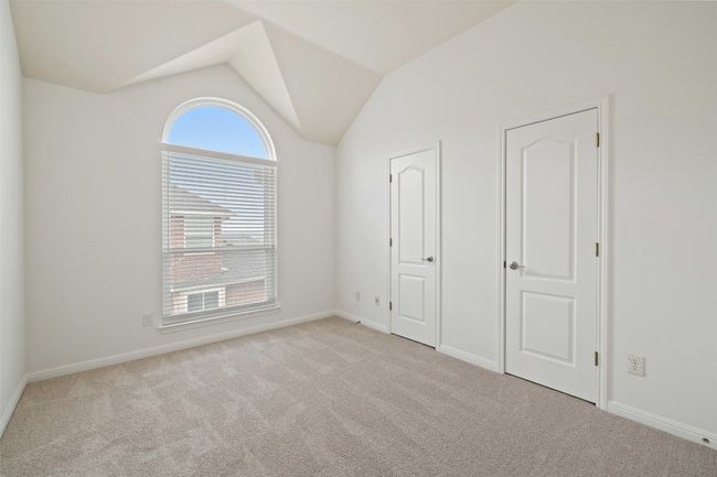Unfurnished bedroom with lofted ceiling and light carpet | Image 32