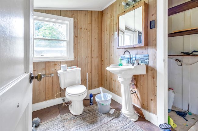 Half bathroom with wooden walls and tile patterned floors | Image 8