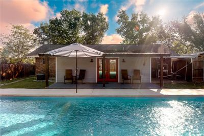 Pool at dusk featuring a patio, french doors, and central AC unit | Image 1