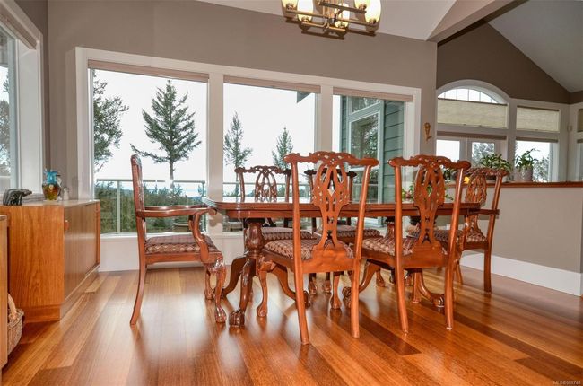 Dining space with plenty of natural light, vaulted ceiling, views and hardwood flooring | Image 6