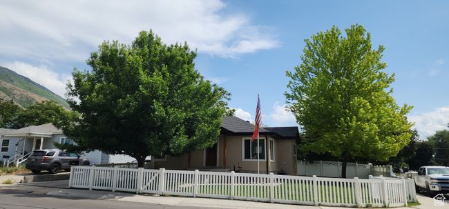 Obstructed view of property with stucco siding, a fenced front yard, and a mountain view | Image 52