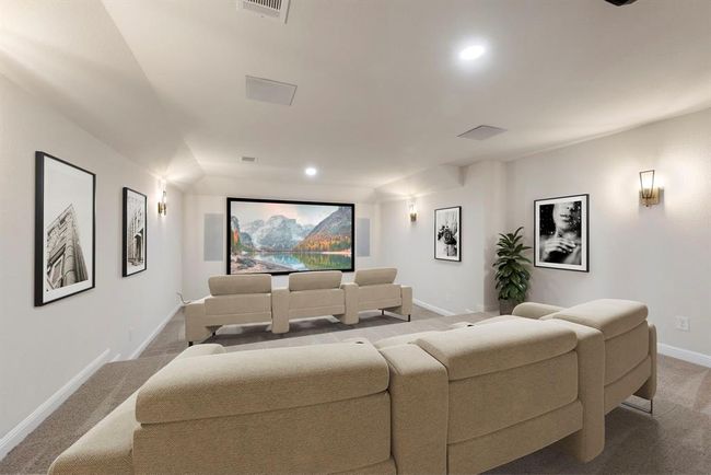 This newly upgraded media room is the ultimate home theater experience—featuring plush tiered seating, integrated surround sound, and dimmable wall sconces for cinematic ambiance. *This photo has been virtually staged.* | Image 36