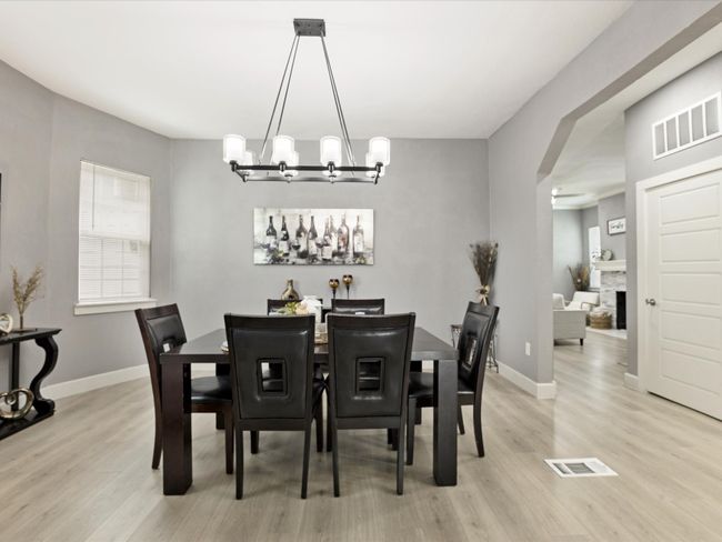 Dining room featuring light wood finished floors, baseboards, and a chandelier | Image 17