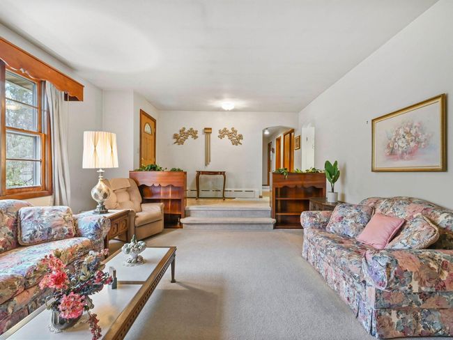 Living room with light colored carpet and a baseboard radiator | Image 7