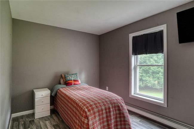 Bedroom with a baseboard heating unit and dark hardwood / wood-style flooring | Image 26