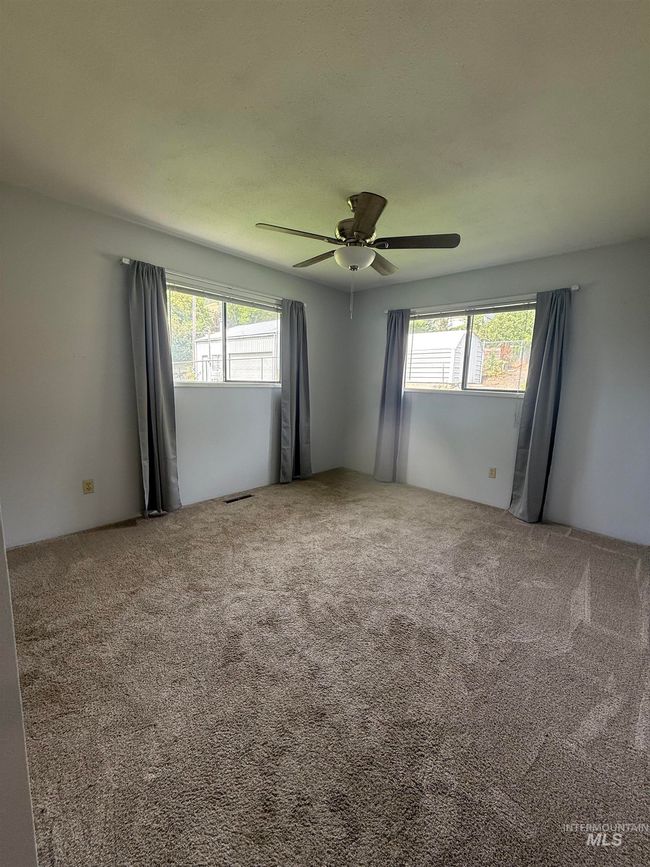 Carpeted spare room featuring a ceiling fan | Image 29