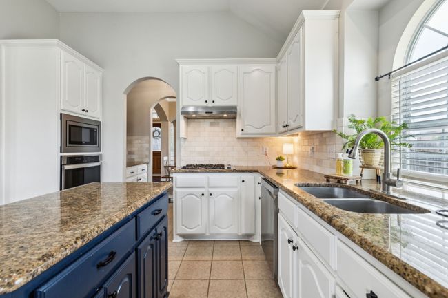 Kitchen featuring a sink, appliances with stainless steel finishes, blue cabinetry, and white cabinetry | Image 13