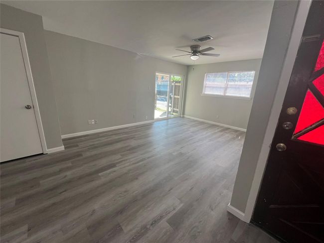 Spare room with a ceiling fan and wood finished floors | Image 4