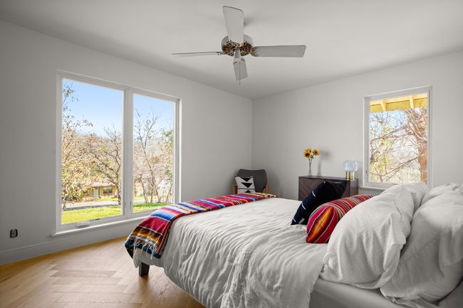 Bedroom featuring ceiling fan, multiple windows, and baseboards | Image 30