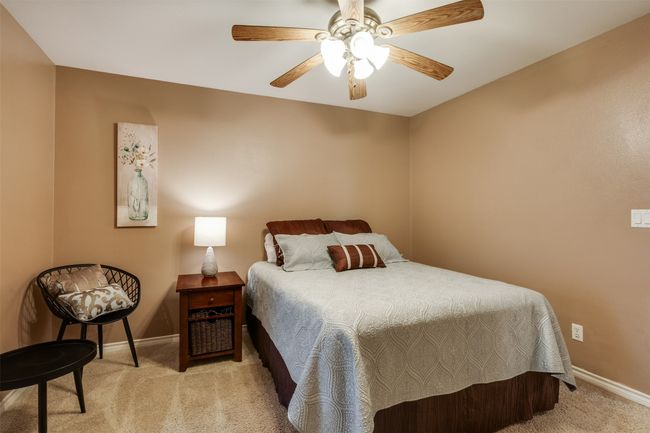 Bedroom with baseboards, light colored carpet, and ceiling fan | Image 13