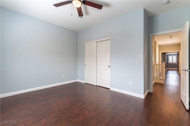 Bedroom featuring dark wood-style flooring, a closet, and baseboards | Image 16