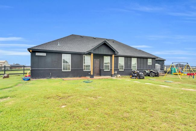 View of front of house featuring a playground, a shingled roof, board and batten siding, and brick siding | Image 25