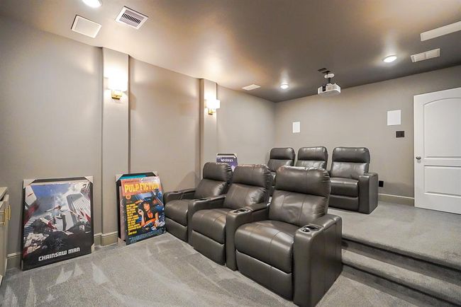 This is a home theater room featuring tiered seating with plush leather recliners, soft ambient lighting, and a projector setup, perfect for a cinematic experience at home. | Image 38