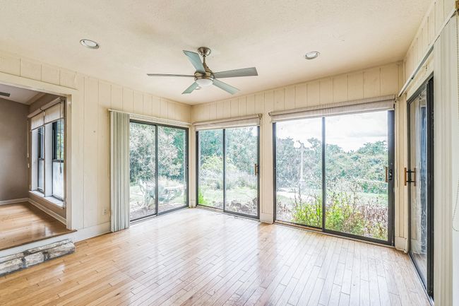 Empty room with a textured ceiling, light wood-style floors, and a ceiling fan | Image 30
