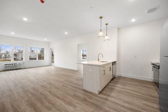 Kitchen featuring a sink, a peninsula, dishwasher, light wood finished floors, and baseboards | Image 6