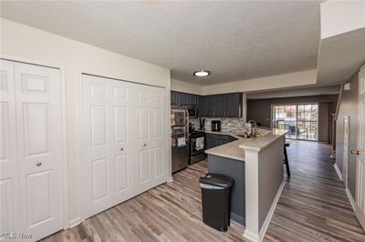 Kitchen with sink, kitchen peninsula, stainless steel appliances, a breakfast bar, and hardwood / wood-style floors | Image 2