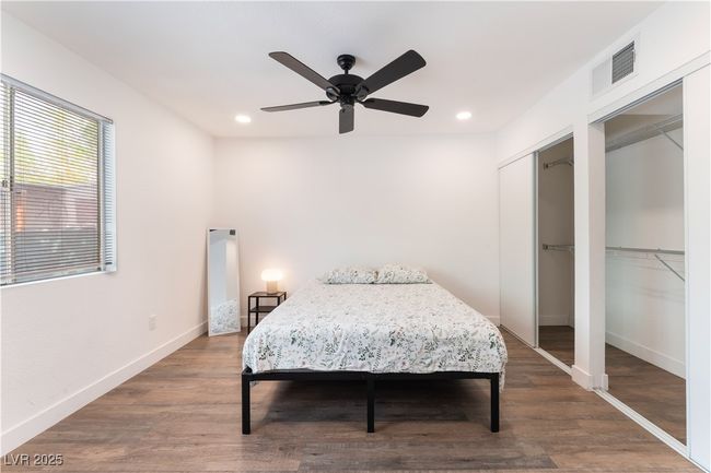 Bedroom featuring two closets, recessed lighting, baseboards, visible vents, and wood finished floors | Image 18