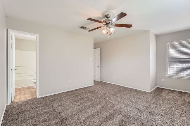 Carpeted empty room with a ceiling fan and baseboards | Image 5