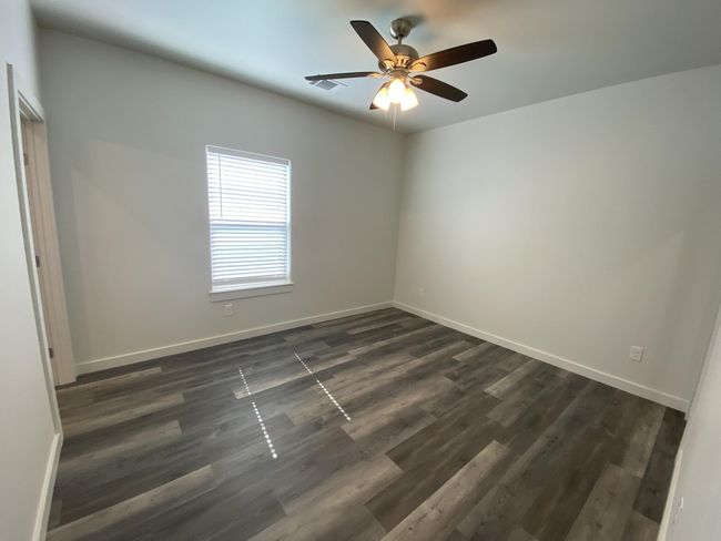 Empty room with baseboards, a ceiling fan, and dark wood-style floors | Image 6