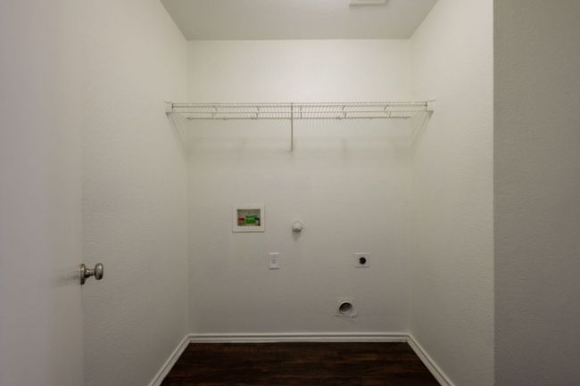 Laundry area featuring hookup for an electric dryer, hookup for a gas dryer, hookup for a washing machine, dark wood finished floors, and baseboards | Image 30