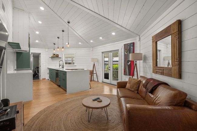Living room featuring wooden walls, lofted ceiling, recessed lighting, wooden ceiling, and light wood-type flooring | Image 6