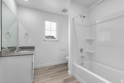 Full bathroom with wood-type flooring, toilet, shower combination, and vanity | Image 3