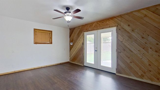 Doorway to outside with french doors, wood walls, baseboards, dark wood-style flooring, and a ceiling fan | Image 17