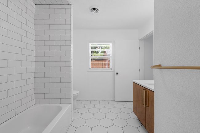 Full bath featuring vanity, toilet, tile patterned flooring, and bathing tub / shower combination | Image 22