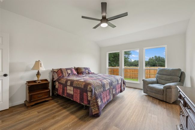 Bedroom with wood finished floors, lofted ceiling, and a ceiling fan | Image 25