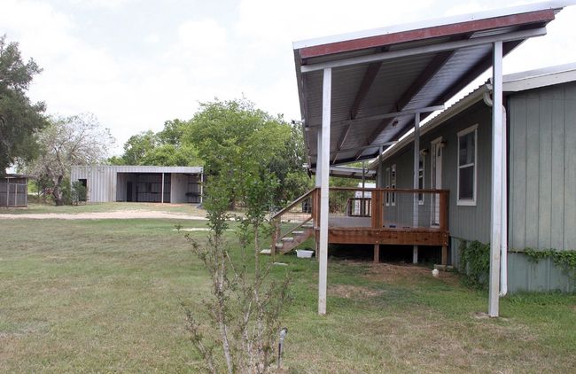 View of green lawn with a deck, a pole building, and an outbuilding | Image 27