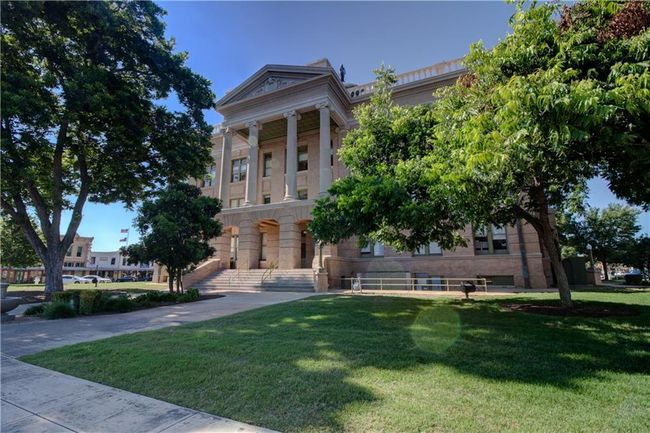 Greek revival house with a front lawn and stone siding | Image 30