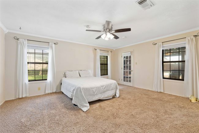 Primary bedroom with ensuite bath and access to back patio | Image 18