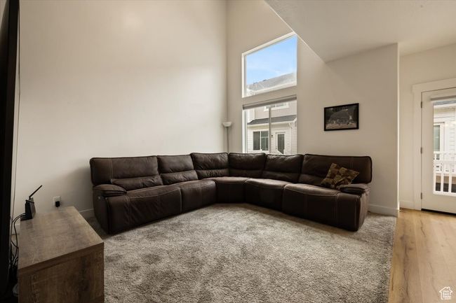 Living area with a high ceiling and wood finished floors | Image 8